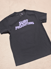 Doom Tee in black with bold purple "Surf Prescriptions" arched lettering across the chest, flat lay